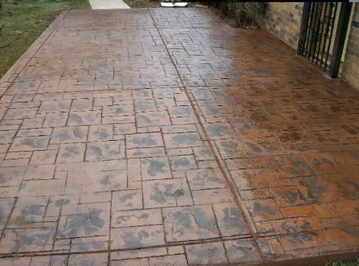 A brick patio with a fence in the background