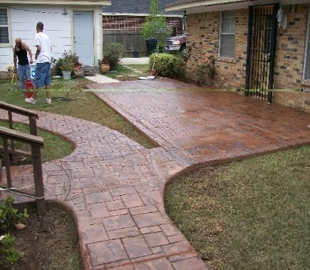 A brick house with a concrete walkway in front of it