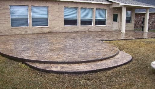 A brick house with a concrete patio in front of it.