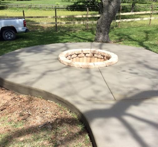 A concrete walkway with a fire pit in the middle