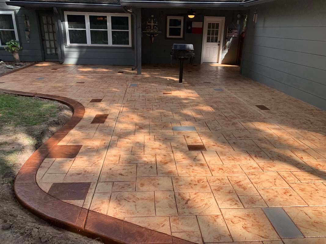 A patio with a grill and a mailbox in front of a house.