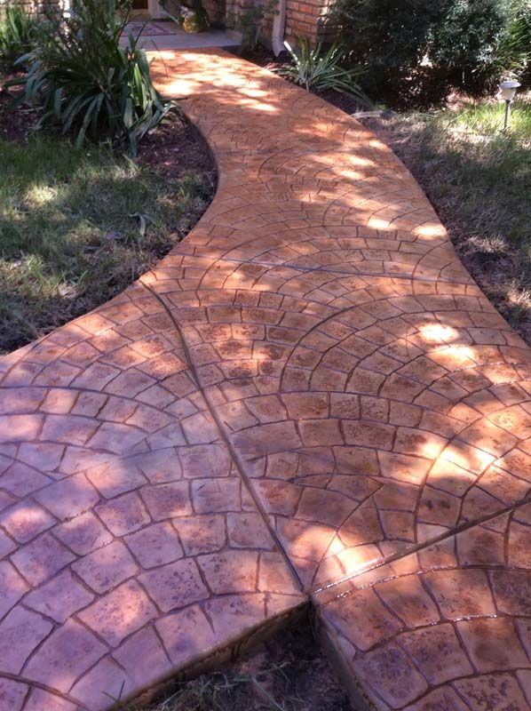 A curved concrete walkway leading to a house.