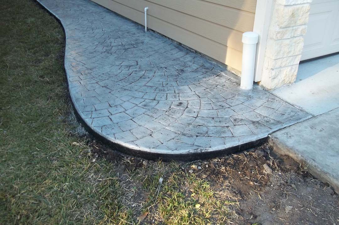 A concrete walkway is being built in front of a house.
