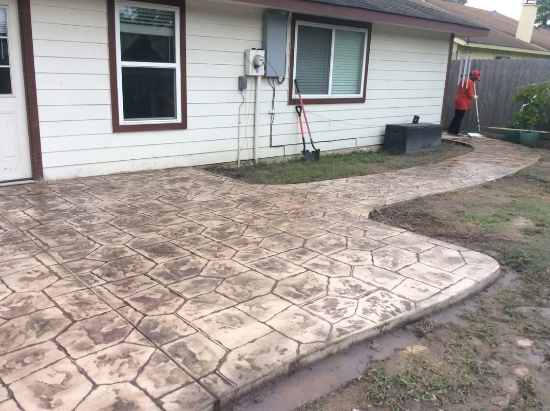 A concrete walkway is being built in front of a house.