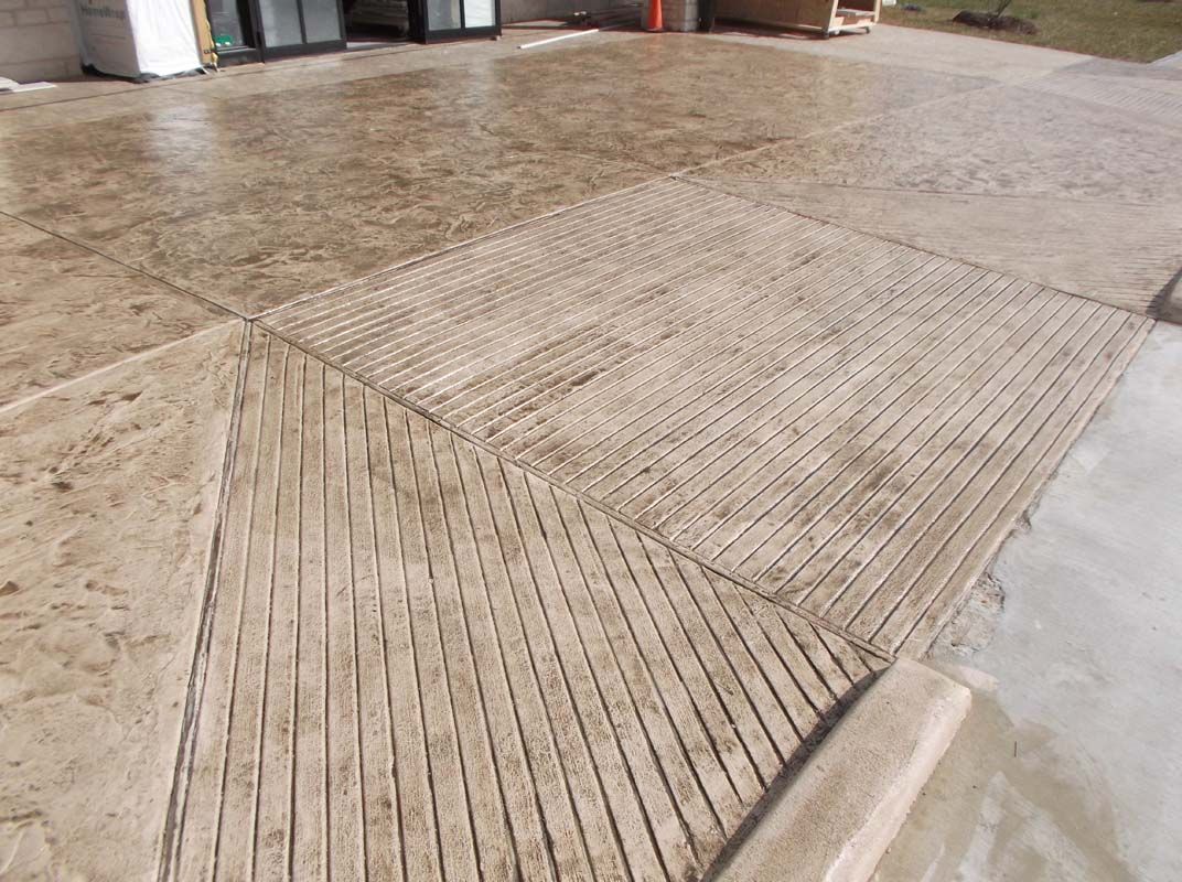 A close up of a concrete driveway with a pattern on it.