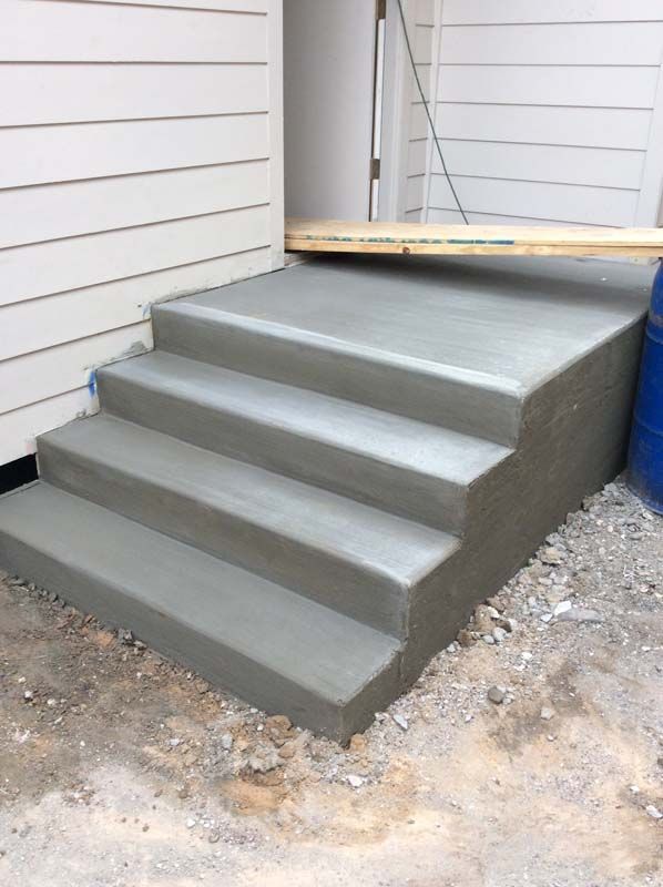 A concrete staircase is being built in front of a house.