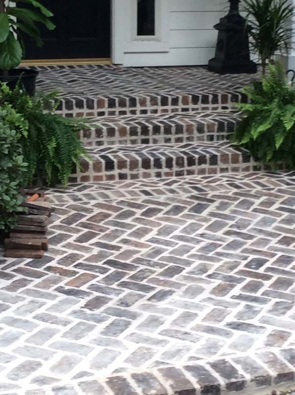 A brick walkway with steps leading up to a door
