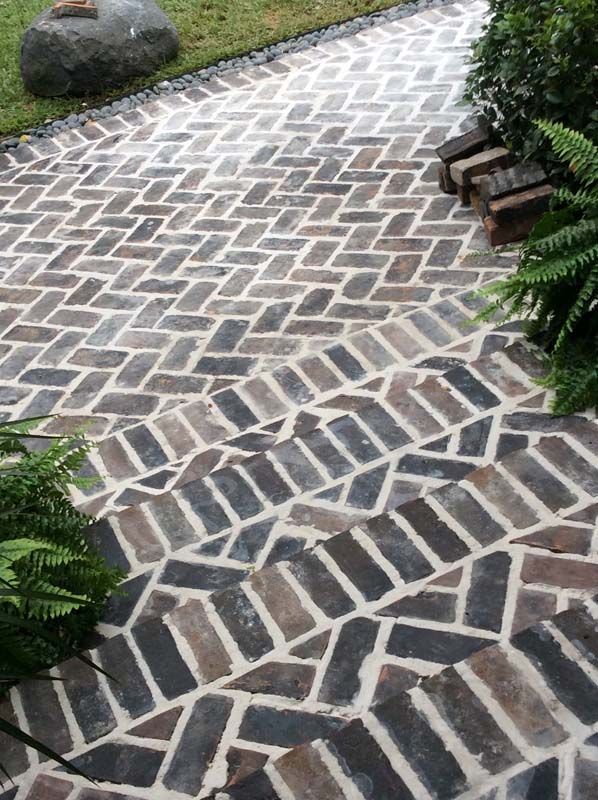 A brick walkway with a herringbone pattern on it