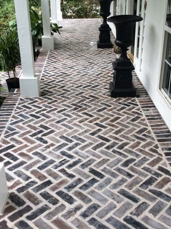A brick walkway with a herringbone pattern on it