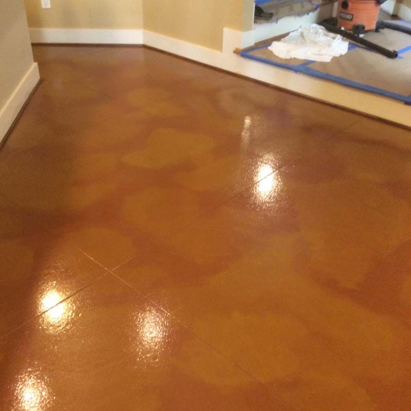 A shiny brown floor with a vacuum cleaner on it