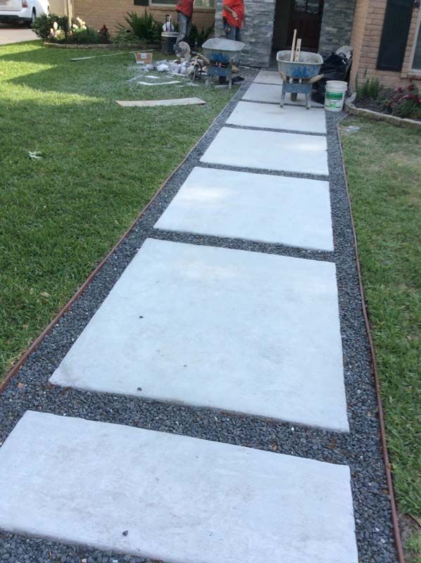 A concrete walkway is being built in front of a house.
