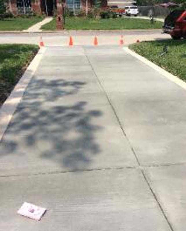 A concrete sidewalk with a shadow of a tree on it.