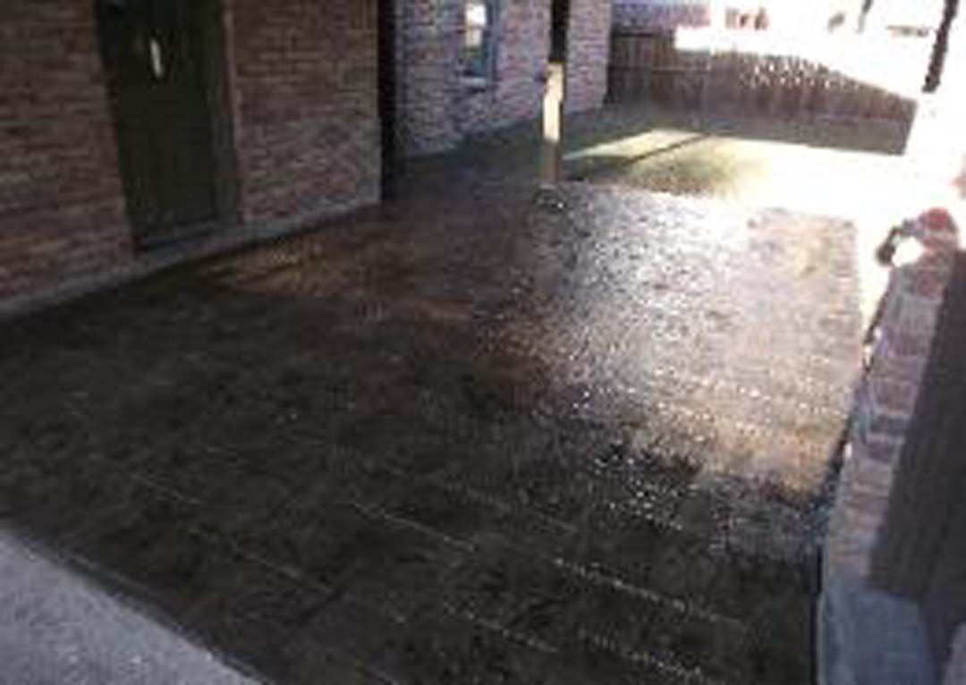 A brick building with a concrete patio in front of it.