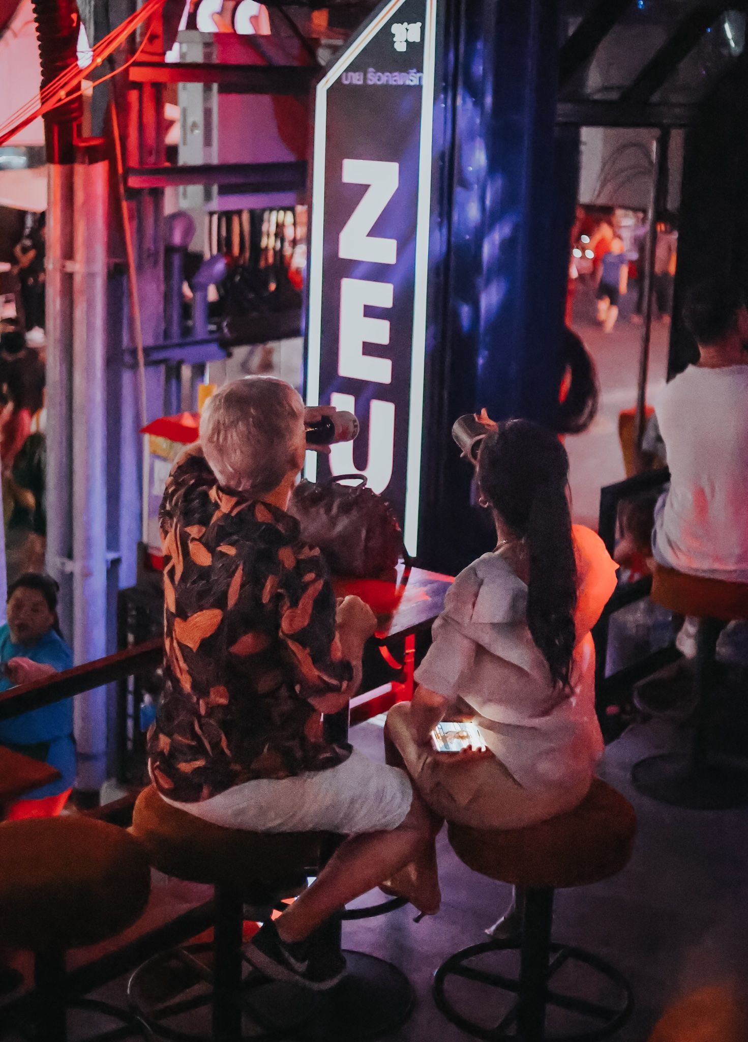 a group of people are sitting at tables in a bar .