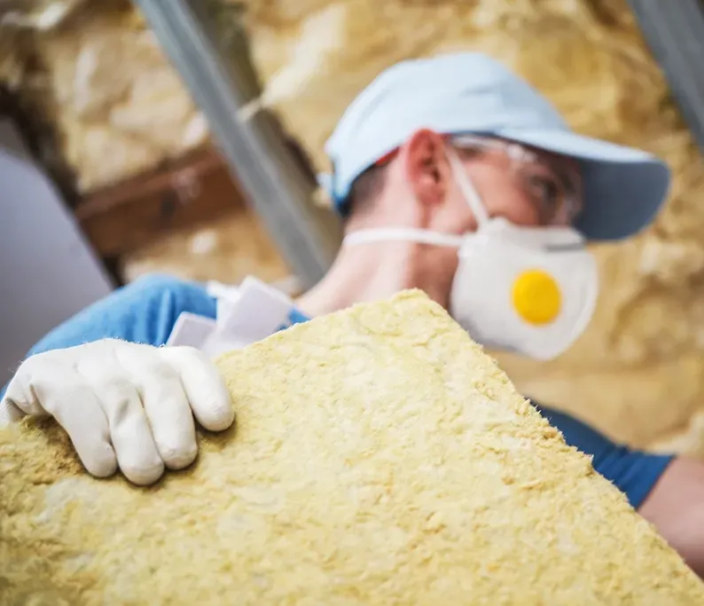 A Man Installing Insulation Batts — Proshield Insulation & Waterproofing In Shell Cove, NSW