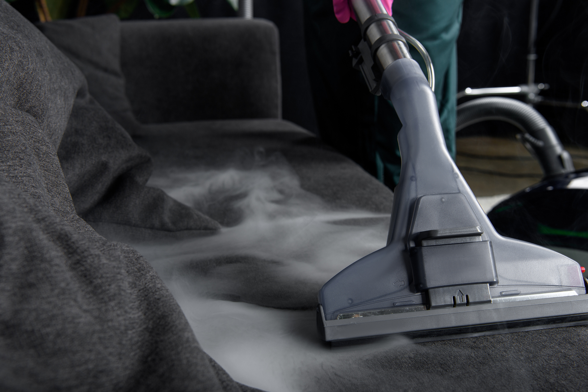 A person is cleaning a couch with a vacuum cleaner. — Durant, OK — James Dry Carpet & Upholstery Cleaning Service