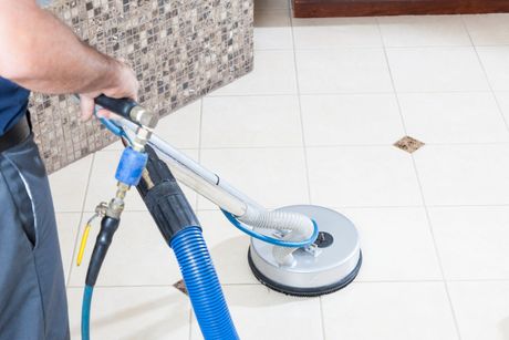 A man is cleaning a tile floor with a vacuum cleaner. — Durant, OK — James Dry Carpet & Upholstery Cleaning Service