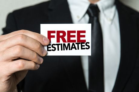 A man in a suit and tie is holding a card that says free estimates — Durant, OK — James Dry Carpet & Upholstery Cleaning Service