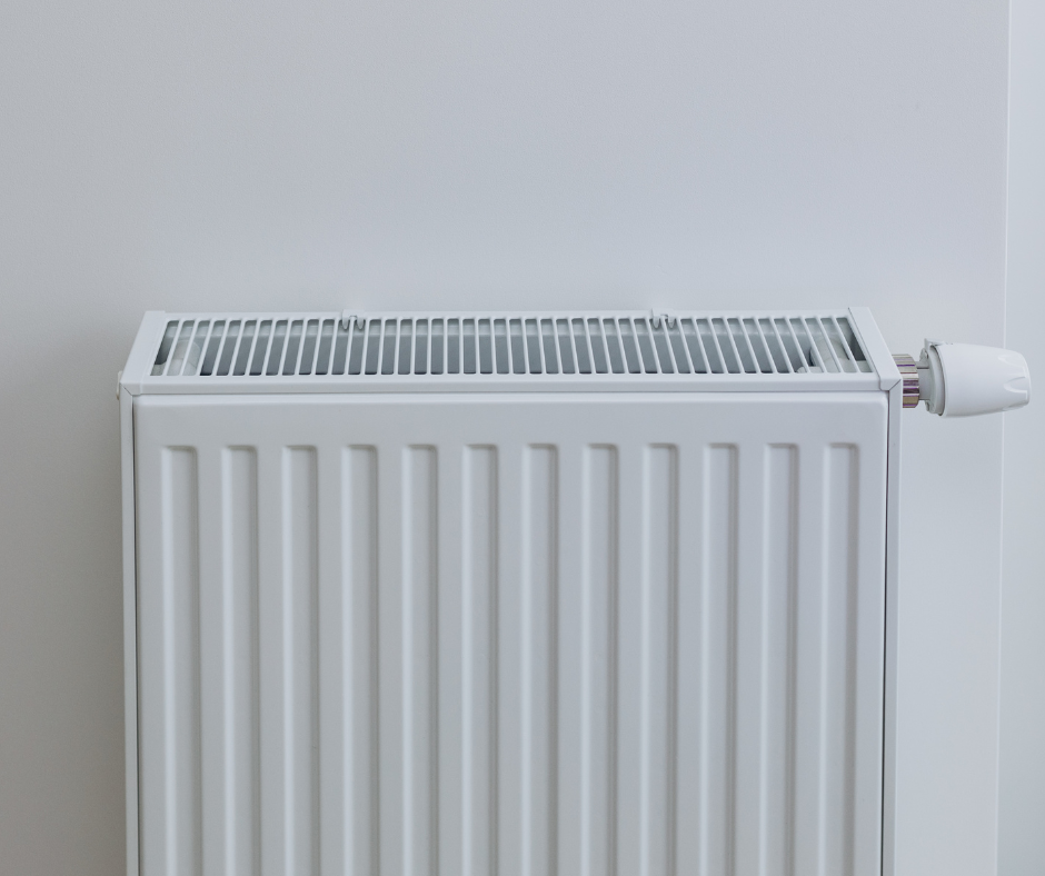 A white radiator is sitting next to a white wall.
