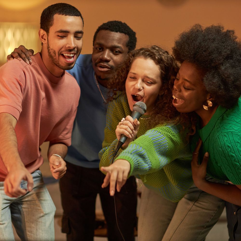 A group of people are singing into a microphone.