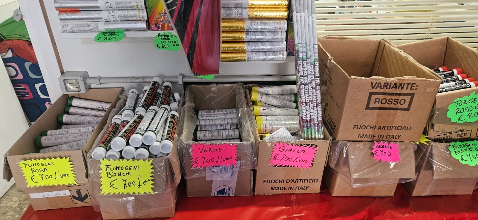 Fuochi d'artificio in vendita in scatole di cartone su un tavolo rosso.