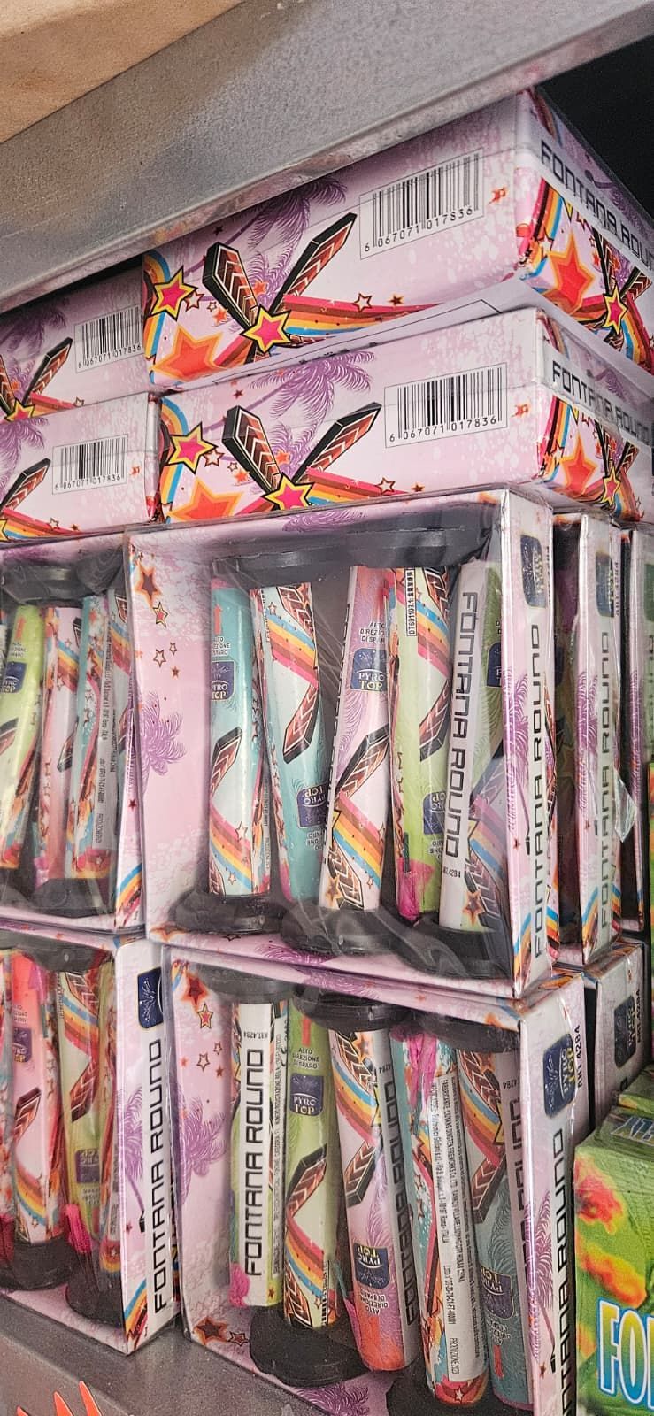 Scatole di penne colorate con disegni di farfalle su uno scaffale.