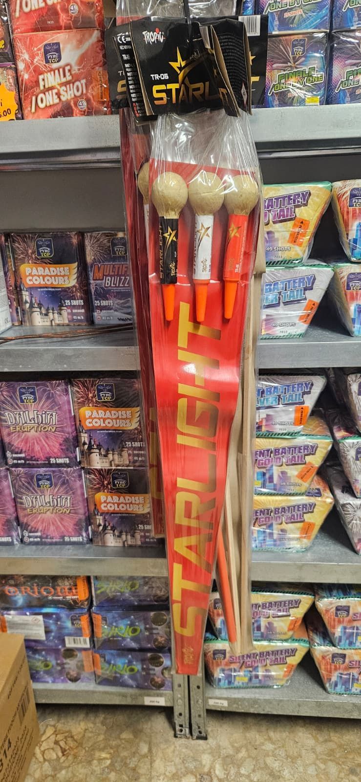 Spettacolo pirotecnico sullo scaffale di un negozio, confezione rossa e bianca. È visibile la scritta 