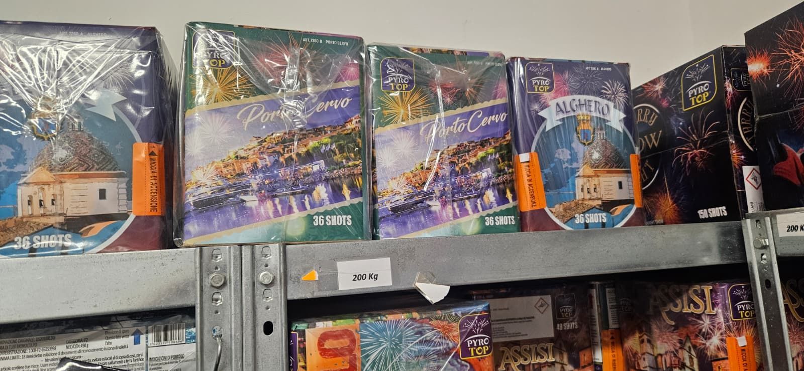 Scaffali pieni di scatole colorate per fuochi d'artificio. Le scatole sono avvolte in plastica trasparente.