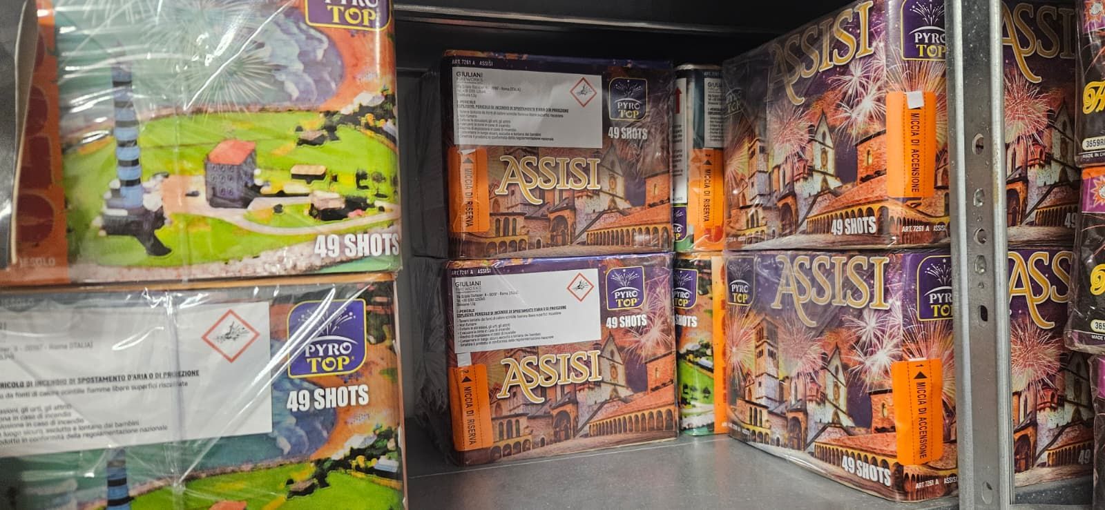 Scaffali pieni di scatole per fuochi d'artificio, di varie dimensioni e design.