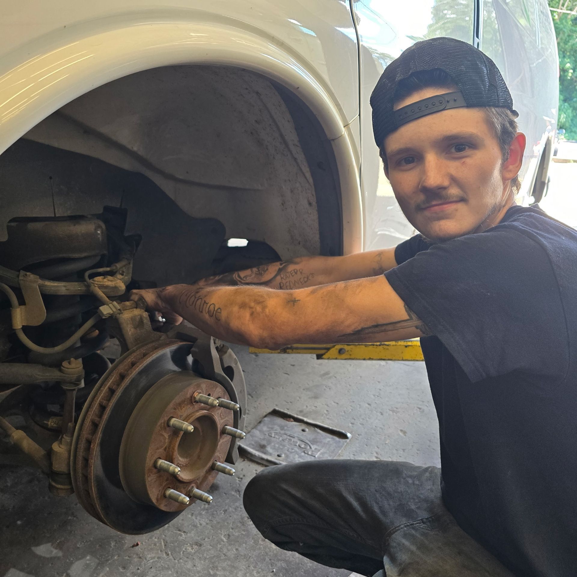 Technician performing brake repair at Auto Tech