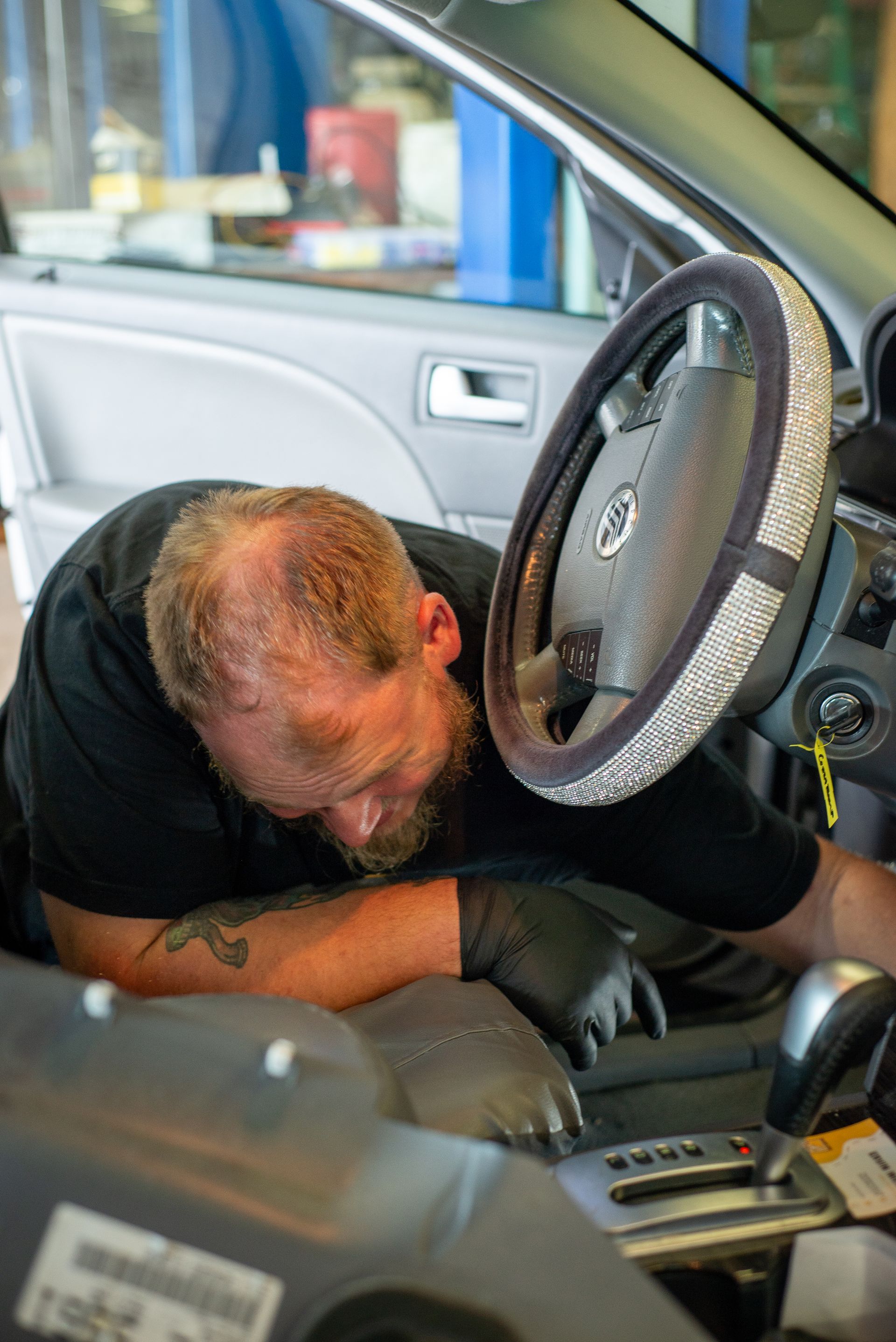 A man is working on a car in a garage.