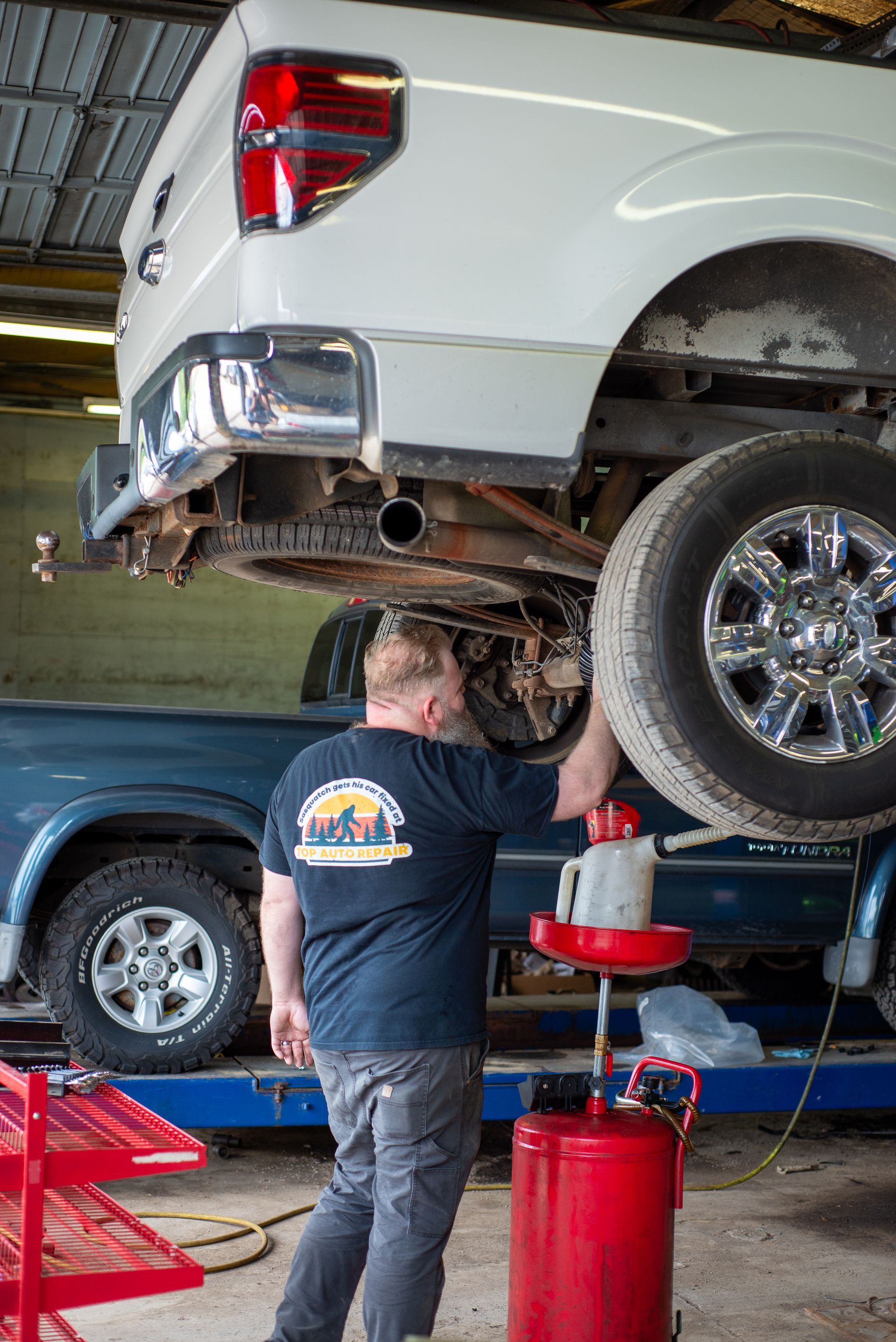 A man is working on a truck in a garage.