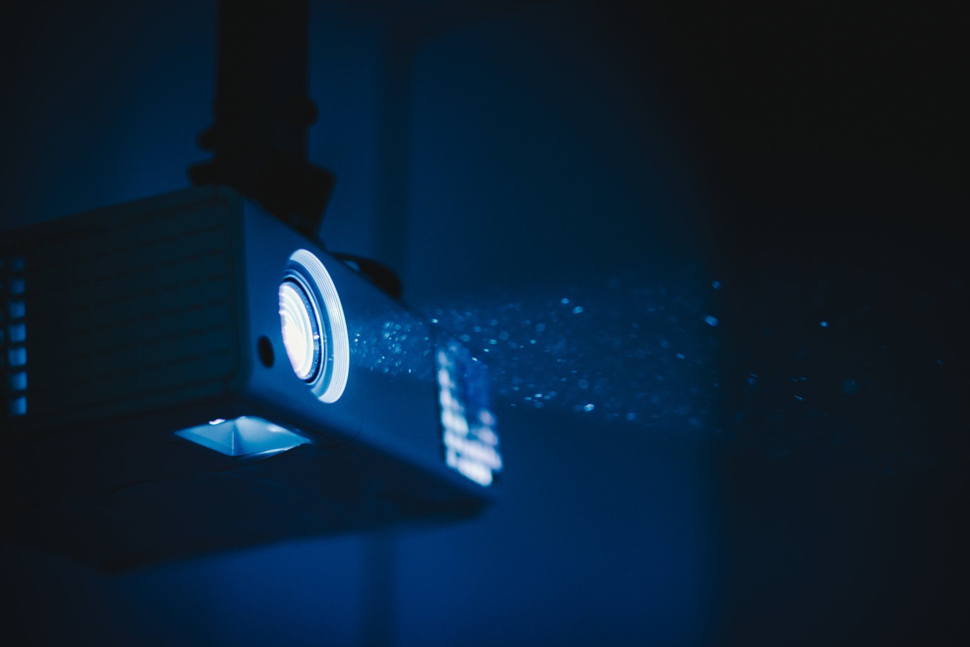 A projector is projecting a blue light on a wall.