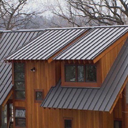 A wooden house with a metal roof and windows