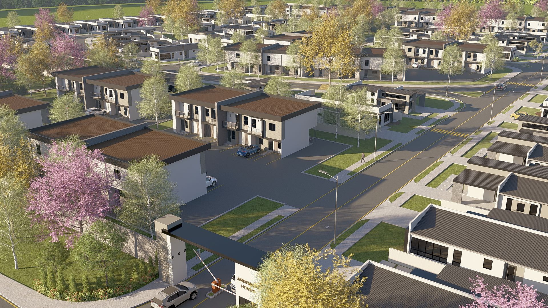 Aerial view of a modern residential neighborhood with townhouses, roads, trees, and a gated entrance.