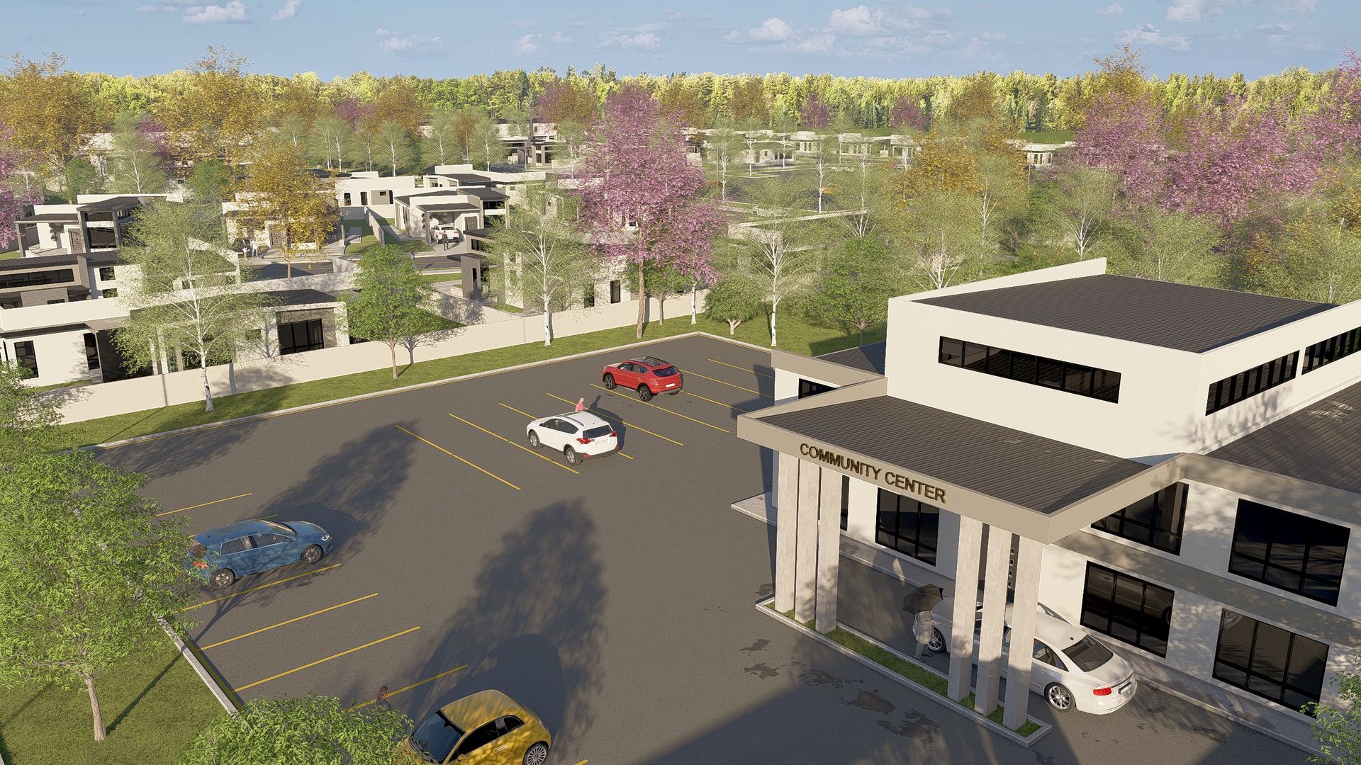 An aerial view of a modern building with a parking lot in front, surrounded by trees and other buildings.