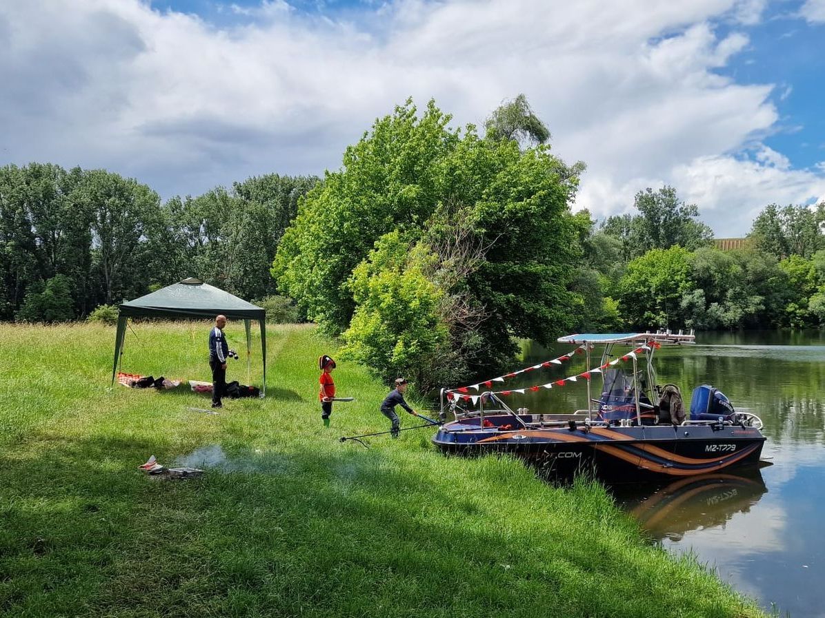 Eine Gruppe von Menschen steht am Ufer eines Sees.