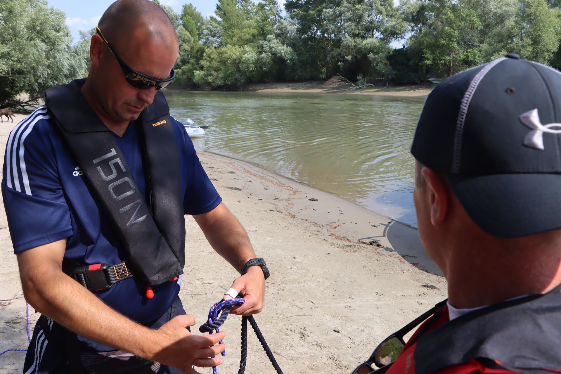 Ein Mann trägt eine Schwimmweste mit der Nummer 150n darauf