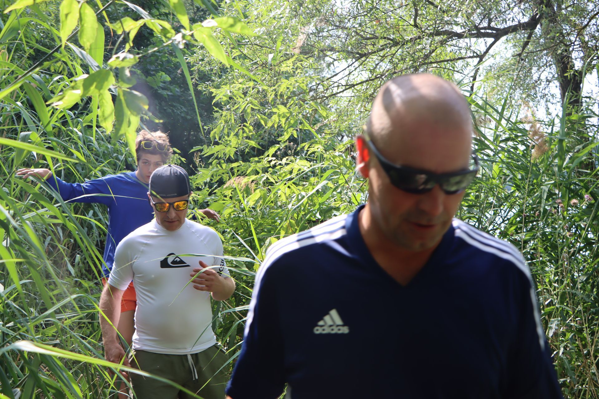 Ein Mann in einem Adidas-Shirt läuft durch einen Wald