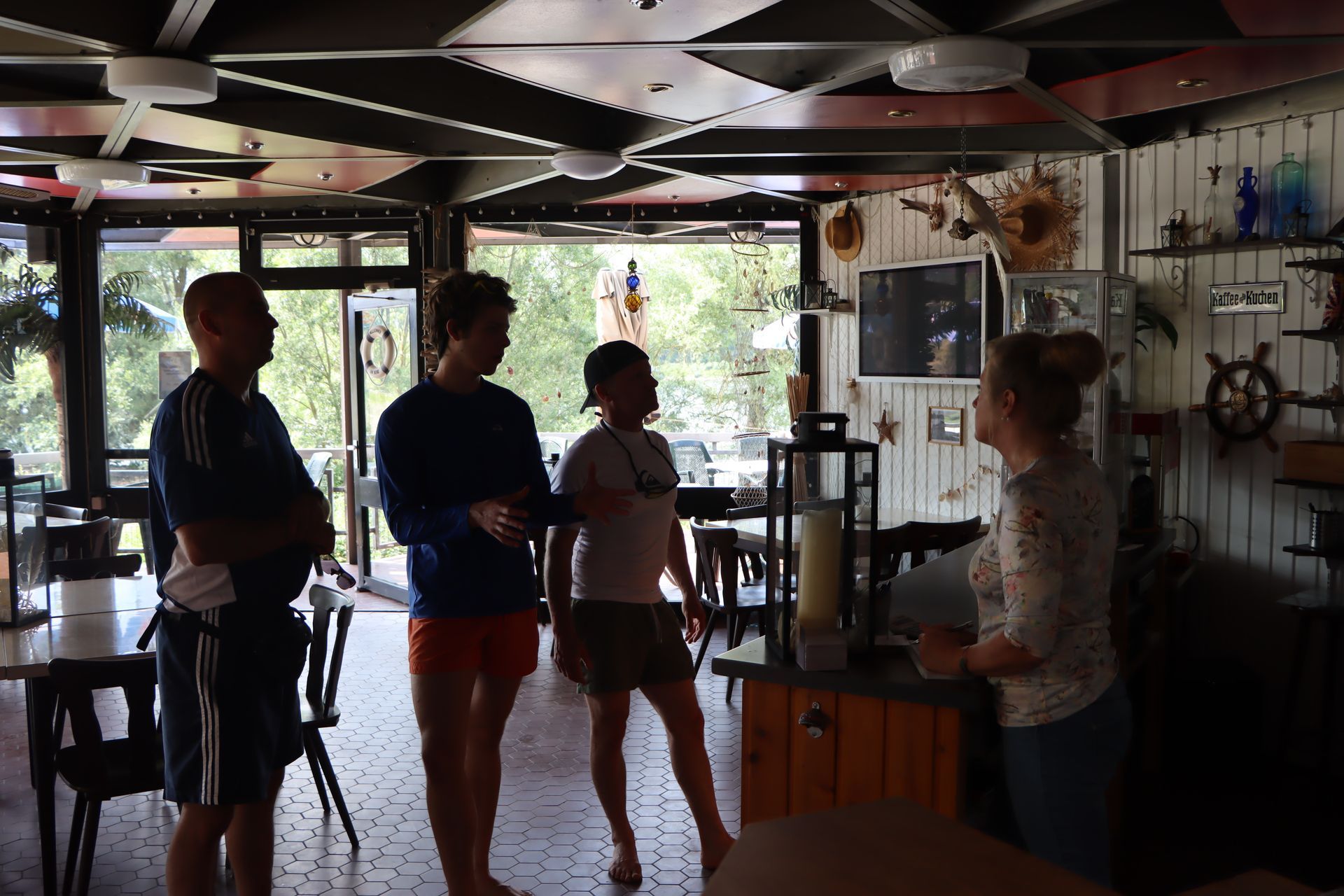 Menschen stehen in einem Raum mit einem Schild mit der Aufschrift „Geöffnet“