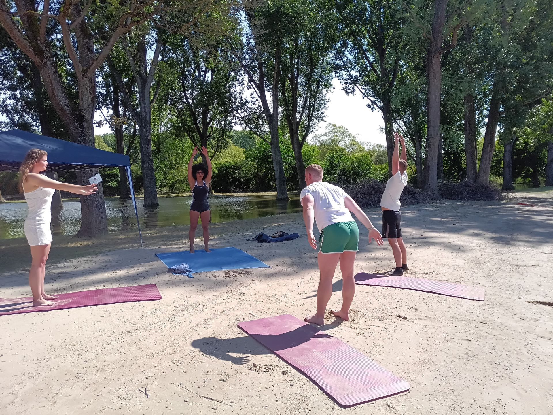 Eine Gruppe Leute macht Yoga am Strand.