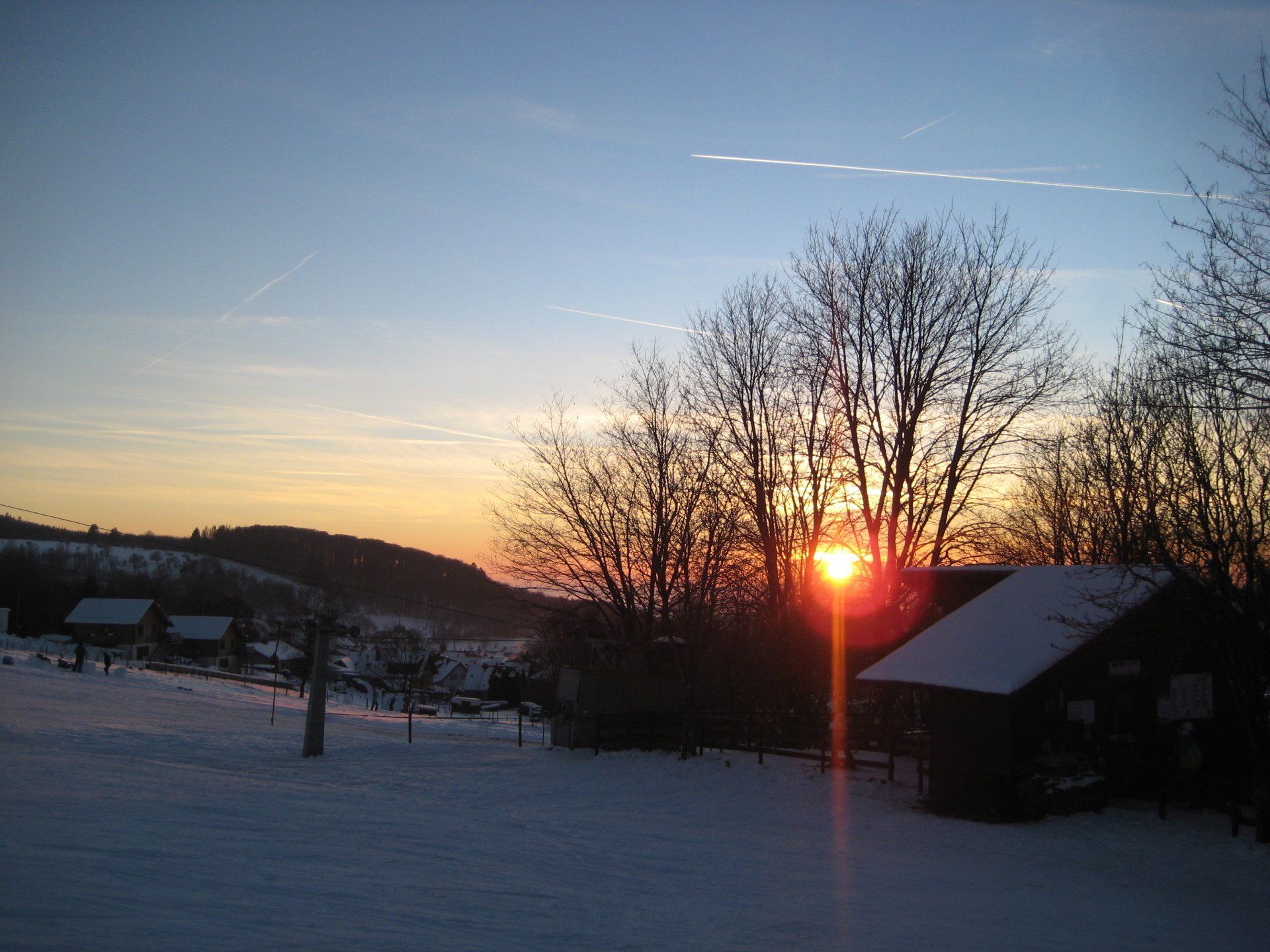 Die Sonne geht über einem schneebedeckten Feld unter