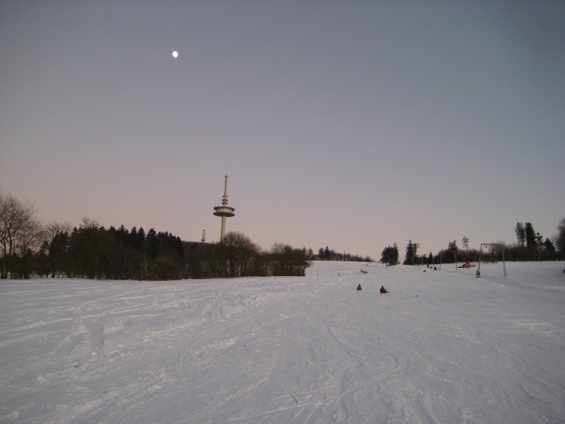 Ein schneebedecktes Feld mit einem Turm im Hintergrund