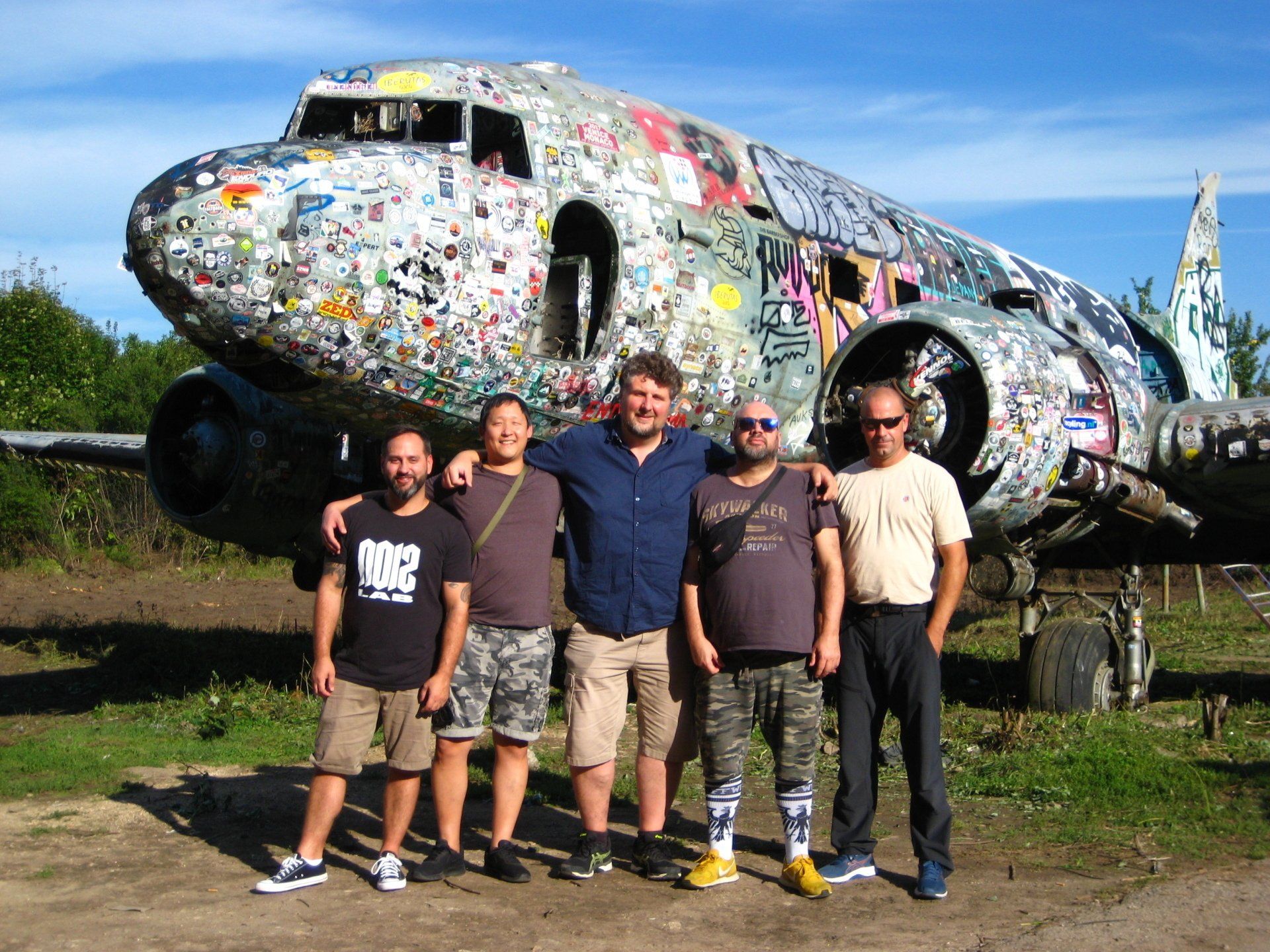Eine Gruppe von Männern steht vor einem Flugzeug mit Aufklebern darauf