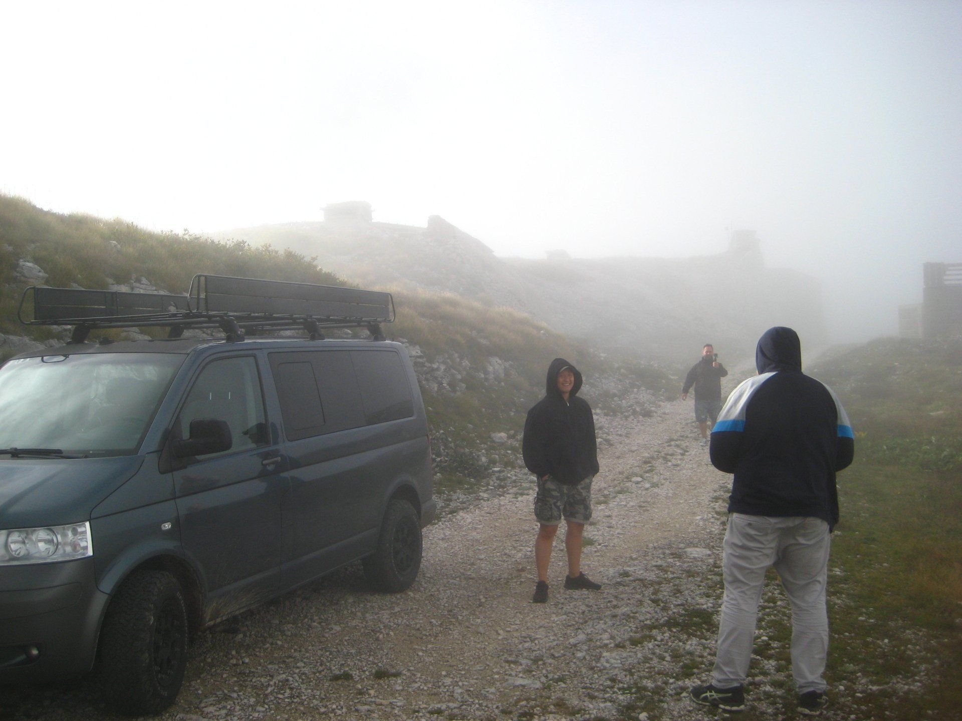 Ein Van mit Dachgepäckträger steht auf einer unbefestigten Straße