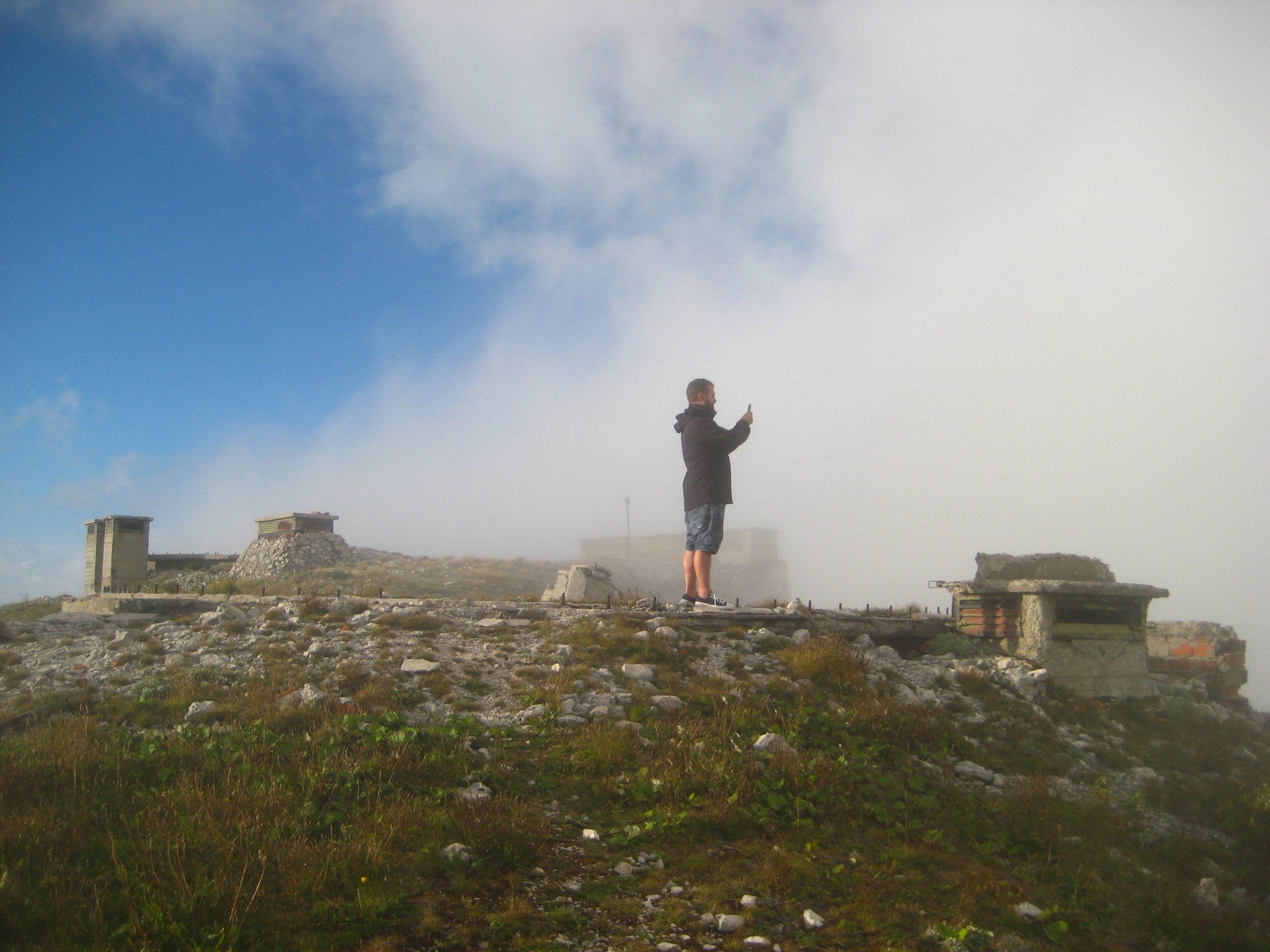 Ein Mann steht auf einem Hügel und macht ein Foto