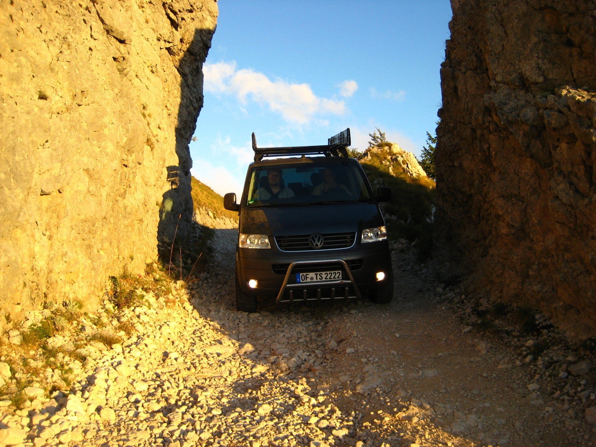 Ein schwarzer Lieferwagen mit Dachgepäckträger hat ein Nummernschild, das mit dem Buchstaben T beginnt