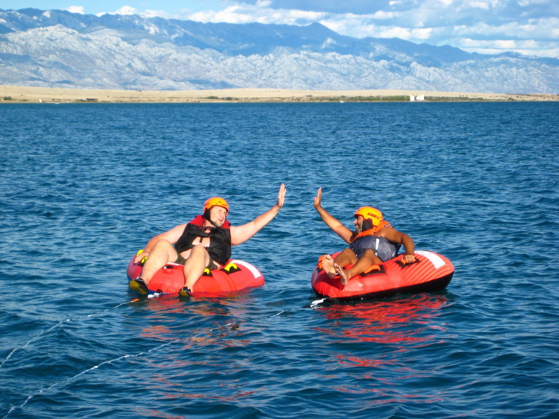 Zwei Menschen geben sich im Wasser ein High Five