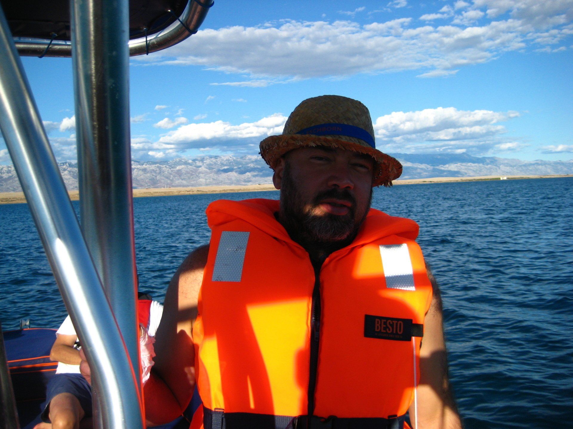 Ein Mann trägt eine orangefarbene Schwimmweste mit der Nummer 831 darauf