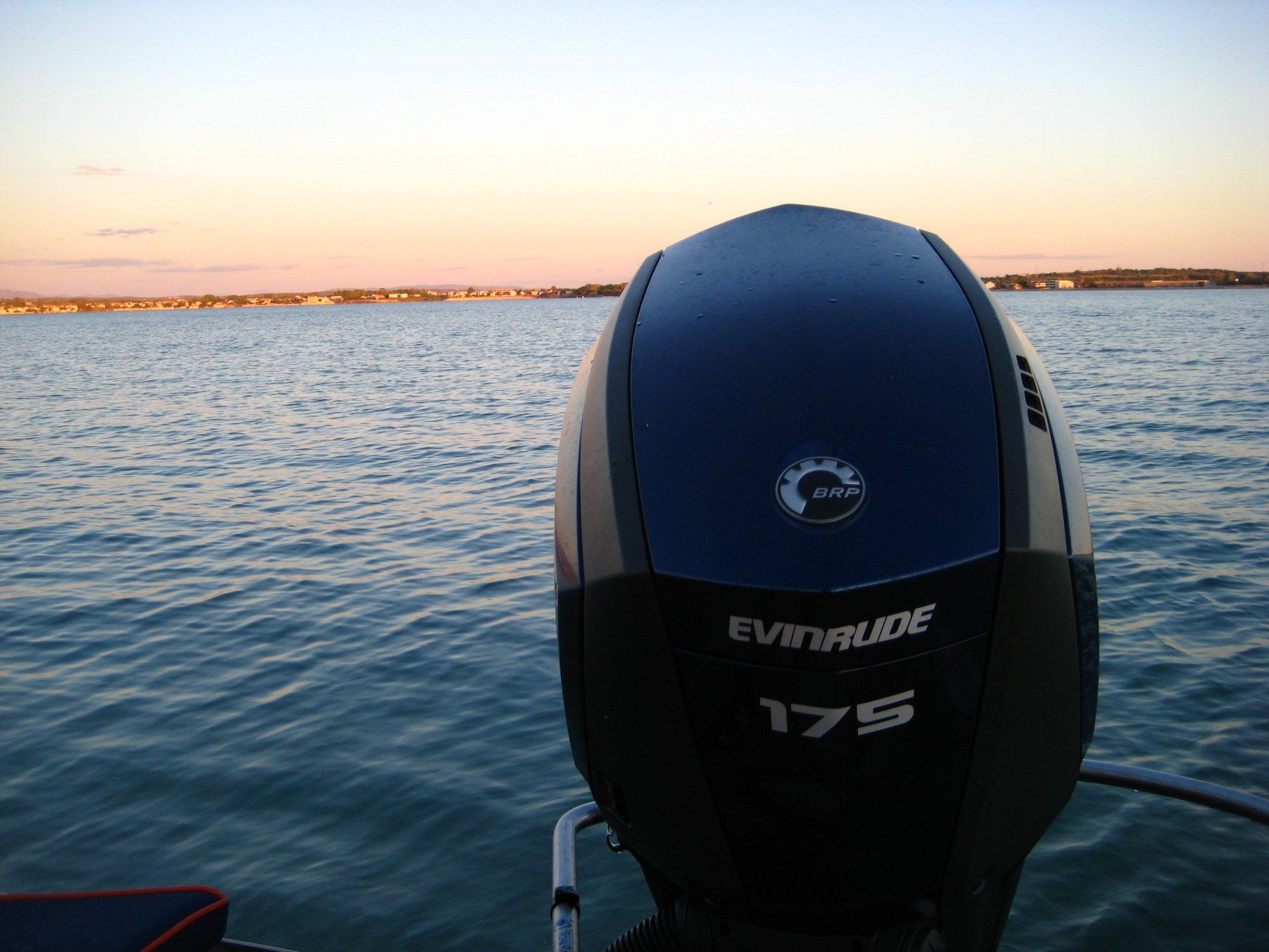 Ein blau-schwarzer Evinrude Außenbordmotor liegt im Wasser